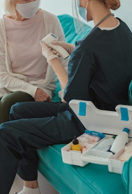 Nurse checking health of senior woman in living room