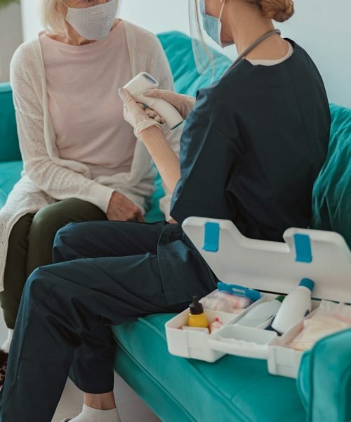 Nurse checking health of senior woman in living room